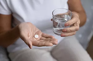 woman holding aspirin tablets
